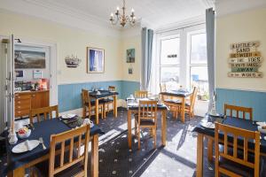 a dining room with tables and chairs and windows at The Tennyson in Bridlington +40 photos