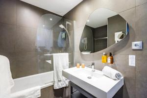 a bathroom with a sink and a mirror at Hotel Vauban Briançon Serre Chevalier in Briançon +38 photos