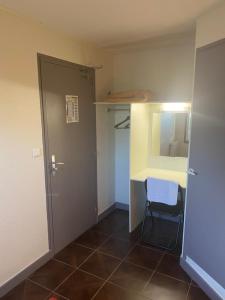 a room with a door and a table and a chair at Fast hôtel Troyes in Barberey-Saint-Sulpice
