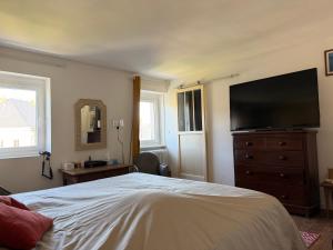 a bedroom with a bed and a flat screen tv at VILLA des Peintres in Étretat