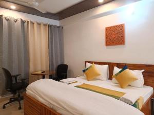 a hotel room with two beds and a table at Hotel Blueberry in New Delhi +6 photos