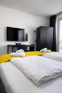 two beds with towels on top of them in a bedroom at Black & Yellow Studio in Augsburg