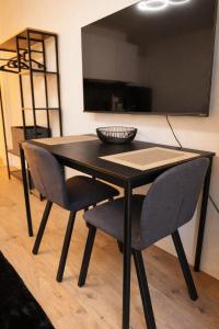 a black table with two chairs and a television at Black & Yellow Studio in Augsburg