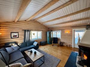 a living room with a couch and a fireplace at Authentic mountain atmosphere at Sjusjøen in Ringsaker