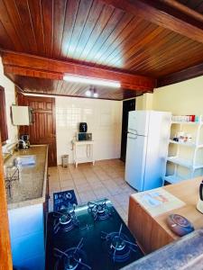 a kitchen with a stove and a white refrigerator at Casarão do Mar in Cabo Frio