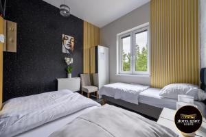 a bedroom with two beds and a window at Hotel Leśny Korne koło Kościerzyny - Kaszuby in Korne