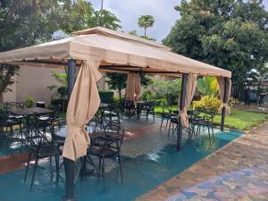 a group of tables and chairs under a large umbrella at Gosen Hotel Lubumbashi in Lubumbashi