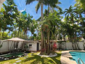 a resort with a swimming pool and palm trees at CulturaHumana Guesthouse in Panama City