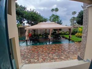 a view of a pool with an umbrella and tables and chairs at Gosen Hotel Lubumbashi in Lubumbashi