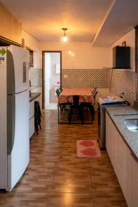 a kitchen with a table and a white refrigerator at Chácara Carlópolis Pr in Carlópolis