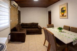 a living room with a table and a couch at Chácara Carlópolis Pr in Carlópolis