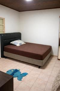a bed sitting in a room with at Chácara Carlópolis Pr in Carlópolis