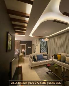 a living room with two couches and a table at Villa karma in Al Rama