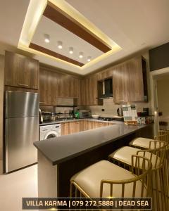 a kitchen with wooden cabinets and a stainless steel appliance at Villa karma in Al Rama