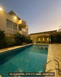 a large swimming pool in front of a building at Villa karma in Al Rama