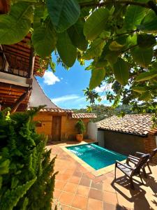 a backyard with a swimming pool and a house at Cabañas el Nopal in San Gil