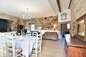 a dining room with a table and a bedroom at La tourelle du Val-d'Arguenon in Pluduno +15 photos