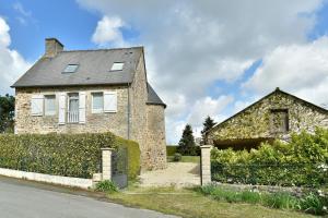 an old brick house with a fence in front of it at La tourelle du Val-d'Arguenon in Pluduno