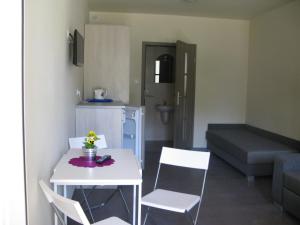 a small living room with a white table and chairs at Ośrodek Wrzos in Boruja