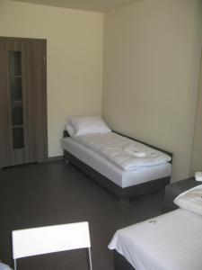a room with two beds and two chairs in it at Ośrodek Wrzos in Boruja