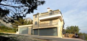 a large building with a large garage at Stone House Bonaca with Sea View in Baška Voda +8 photos