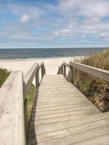 a wooden boardwalk leading to a beach with the ocean at Calma Home in San Luis
