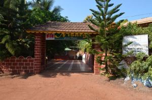 a brick entrance to a building with a sign on it at Nisarg Resort in Guhagar