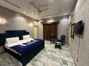 a bedroom with a bed and a flat screen tv at Hotel Sereena residence in Multan