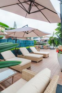 a group of chairs and umbrellas on a patio at Hotel Rio Guayas by Art Hotels in Guayaquil