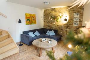 a living room with a blue couch and a table at De Moolt Vakantiewoningen in Eckelrade