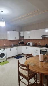 a kitchen with a table and a washing machine at appartement luxe in Berkane