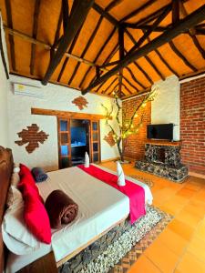 a bedroom with a large bed with red pillows at Cabañas el Nopal in San Gil