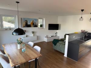 a kitchen and living room with a table and a couch at Seeblick Lünne Emsland in Lünne
