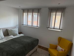 a bedroom with a bed and a yellow chair at Seeblick Lünne Emsland in Lünne