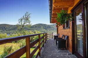 a balcony of a house with a view of the mountains at Barnilka House Klimkówka in Klimkówka