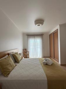 a bedroom with a large bed with two pillows at Albufeira Mar Vilas in Albufeira