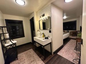 a bathroom with a sink and a mirror at The Boardwalk Hotel in Saint Ignace +27 photos