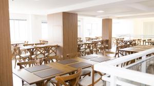 an empty restaurant with wooden tables and chairs at Nostro Hotel in Pato Branco