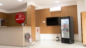 a store with a refrigerator and a tv on a wall at Nostro Hotel in Pato Branco