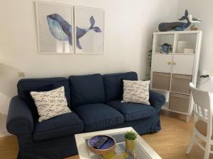 a living room with a blue couch and a table at La ballena de rayas in Tazones