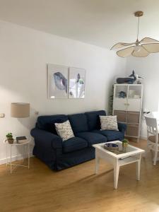 a living room with a blue couch and a table at La ballena de rayas in Tazones