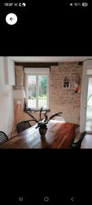 a living room with a wooden table with chairs at La voyageuse in Leuhan