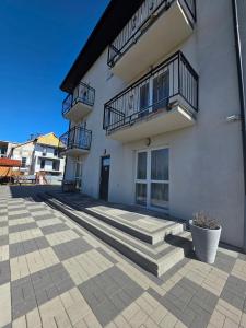 a white building with stairs and a balcony at U Piotra in Sarbinowo