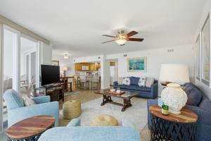 a living room with blue furniture and a ceiling fan at SeaSpray Riverside 312 in Perdido Key