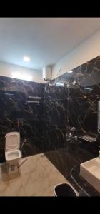 a bathroom with a sink and a black marble wall at Badri Vishal in Varanasi