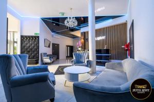 a lobby with blue chairs and a couch and a table at Hotel Leśny Korne koło Kościerzyny - Kaszuby in Korne