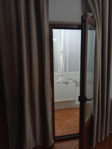 eine offene Tür zu einem Zimmer mit einem Vorhang in der Unterkunft imocris in Fălticeni