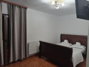 ein Schlafzimmer mit einem Bett und einem Vorhang in der Unterkunft imocris in Fălticeni