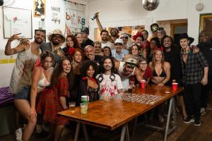 a group of people posing for a picture at a table at Books Hostel in Rio de Janeiro