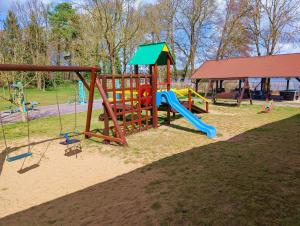 a park with a playground with a slide and swings at Ośrodek Wrzos in Boruja
